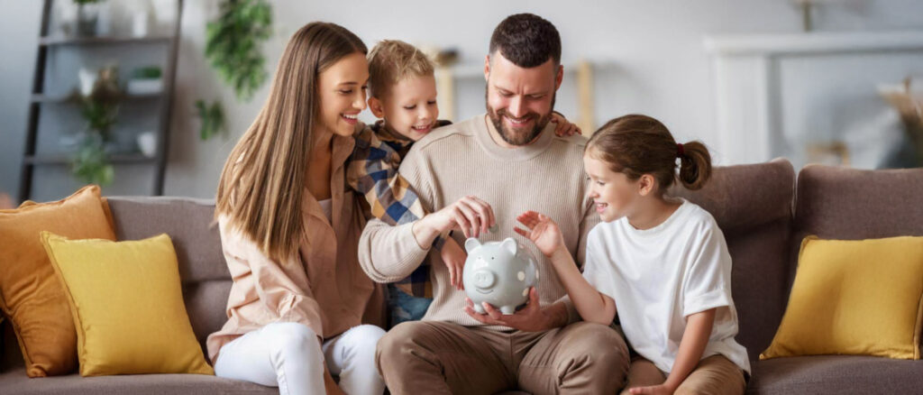 Cozy family in their home putting money into a piggy bank